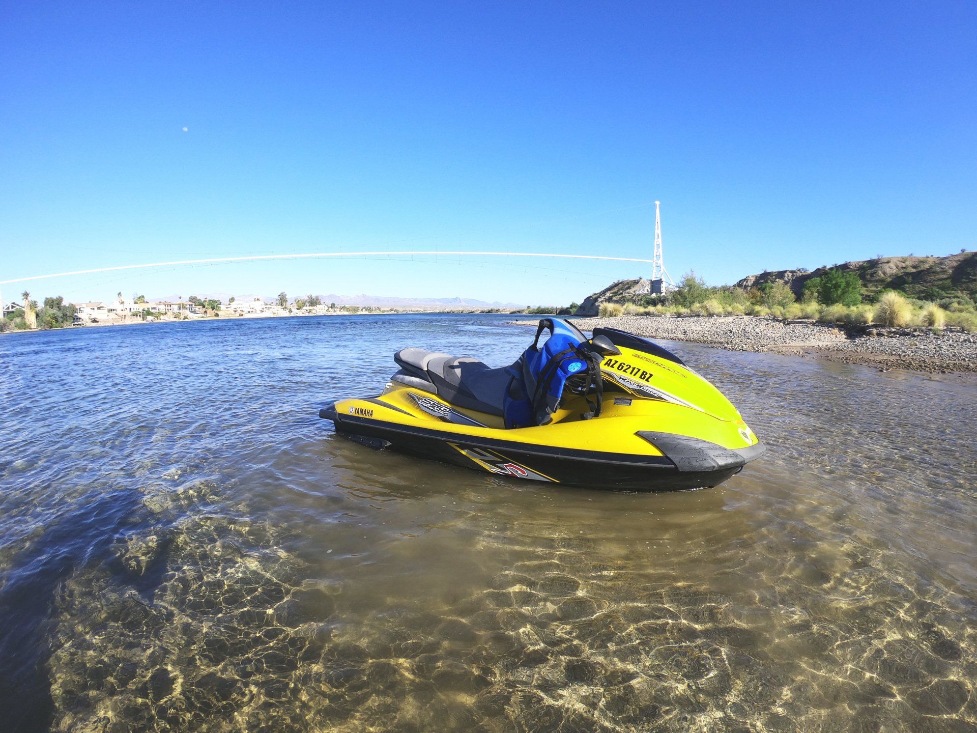 A yellow and blue jet ski is floating on top of a body of water.