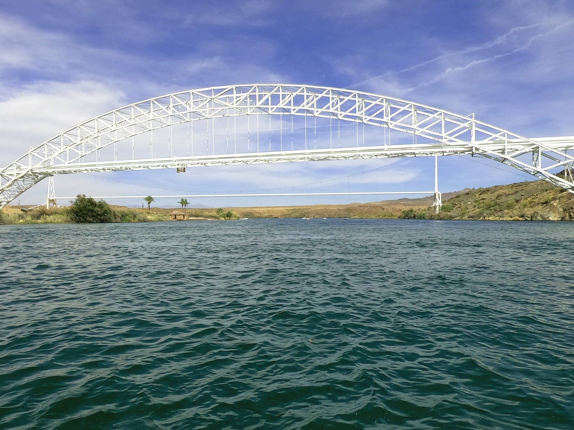 A bridge over a body of water with a blue sky in the background.