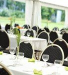 A banquet hall with tables and chairs set up for a wedding reception.