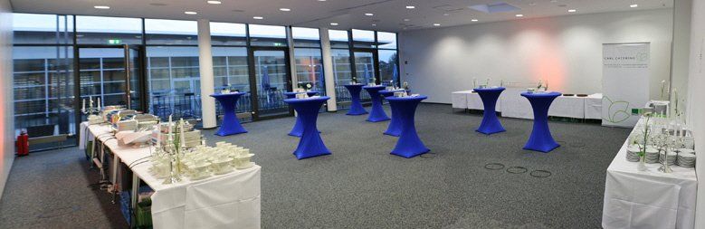 A large room with blue tables and white tables.