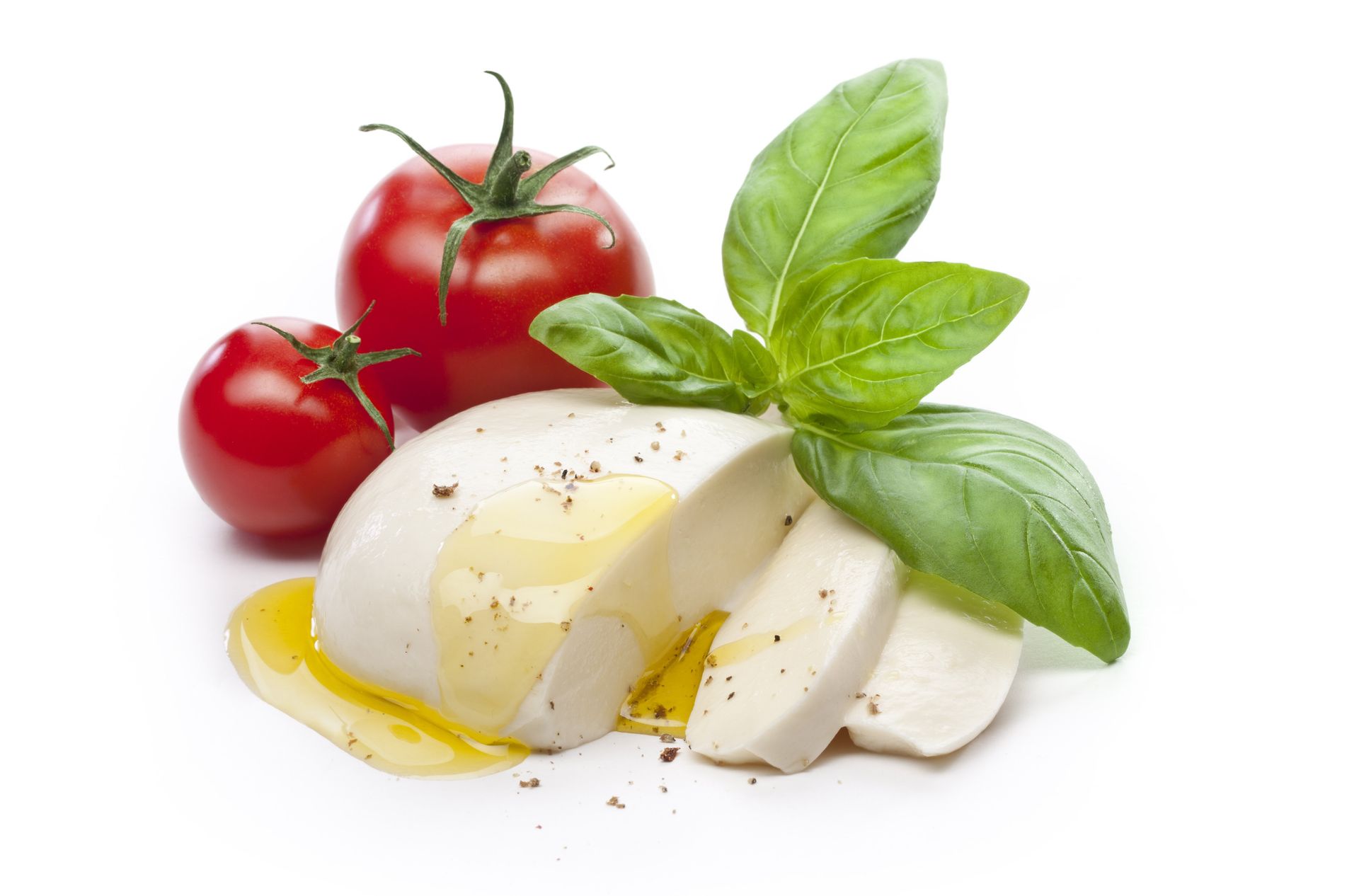 Sliced mozzarella cheese with tomatoes and basil on a white background