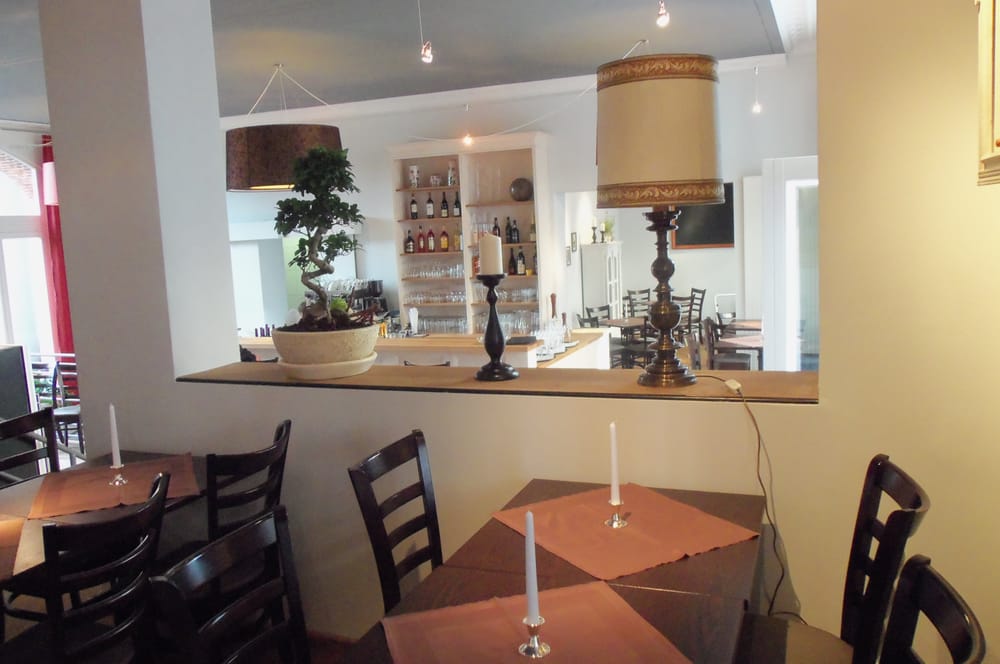 A restaurant with tables and chairs and candles on them