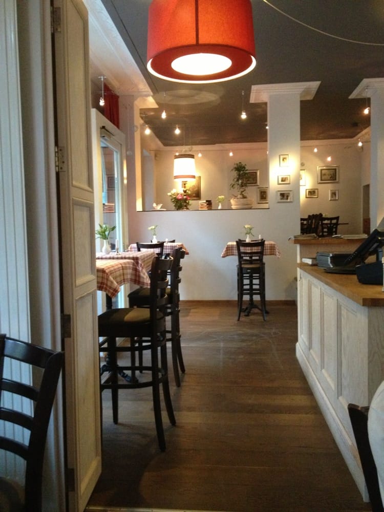 A restaurant with tables and chairs and a red lamp hanging from the ceiling