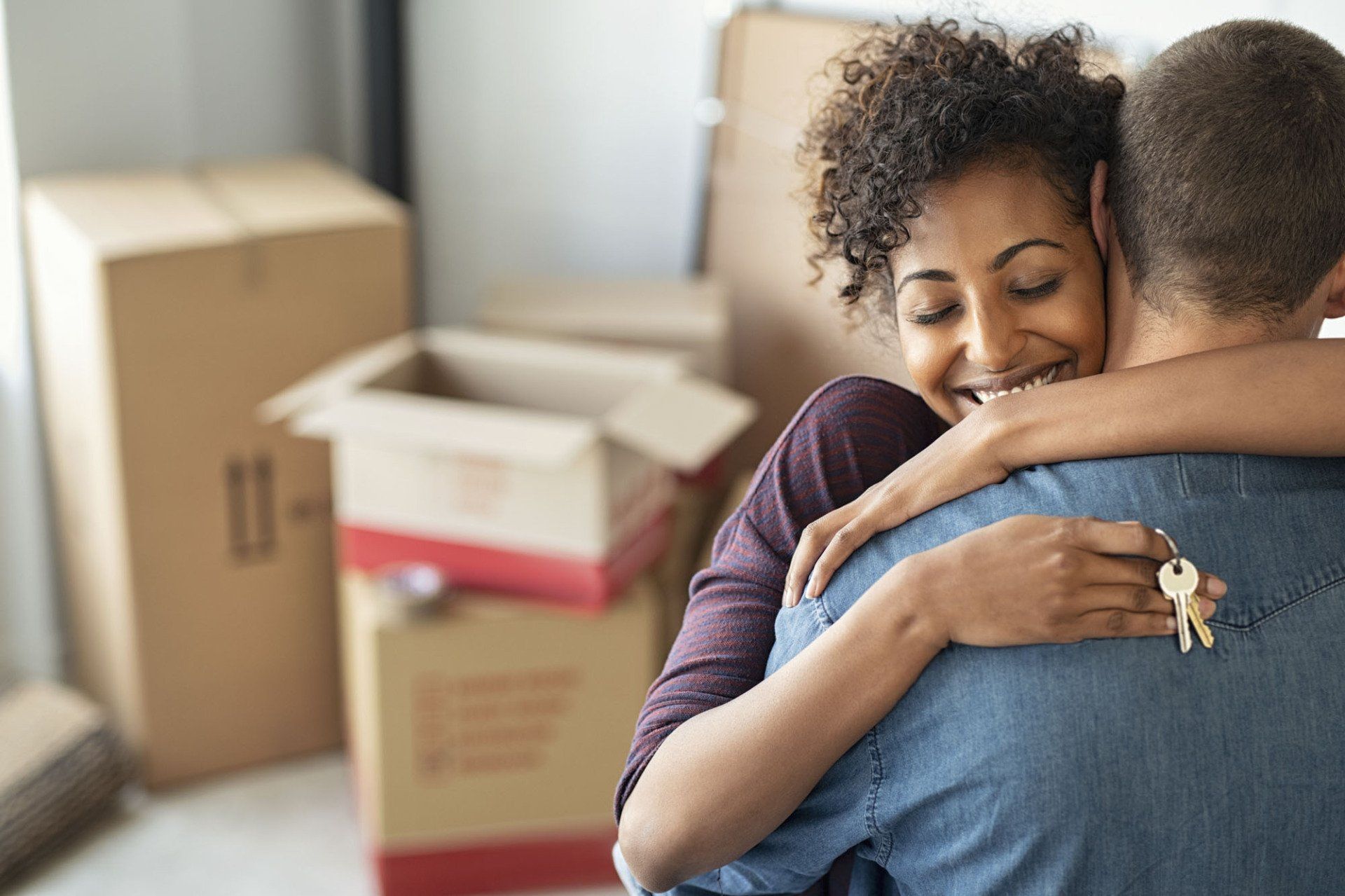 couple with moving boxes and keys