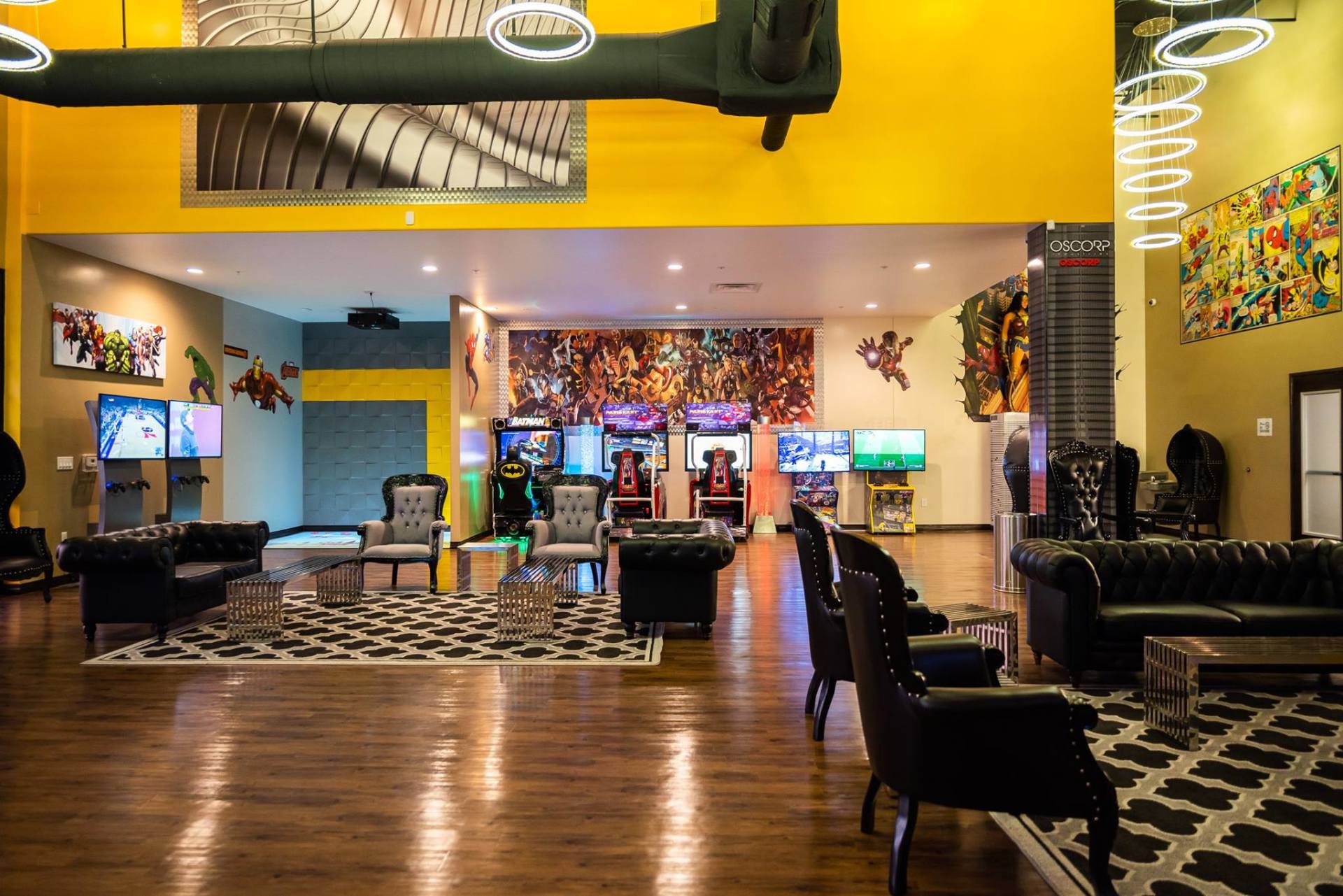Stylish restaurant lounge with black chairs, wood floors, yellow walls, and colorful backlit bar area