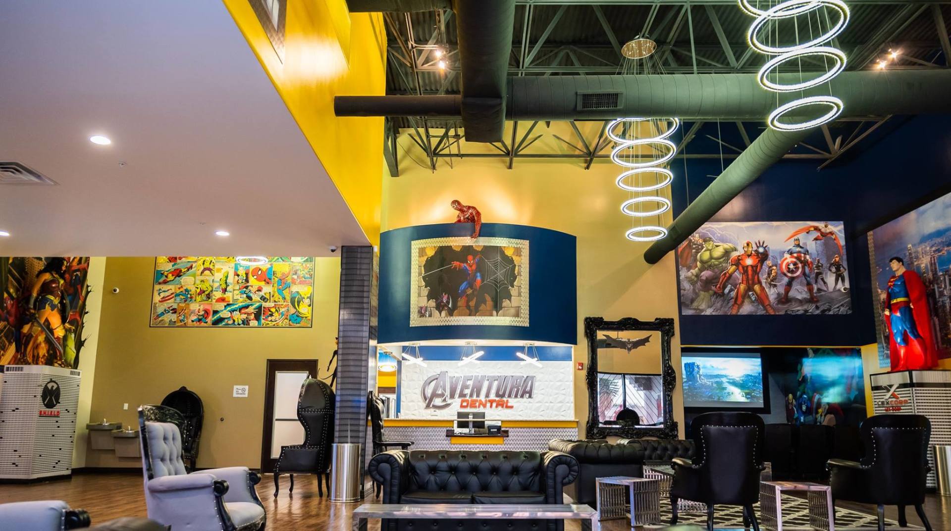 Bright, modern lounge with colorful wall art, high ceiling, hanging spiral lights, and seating area