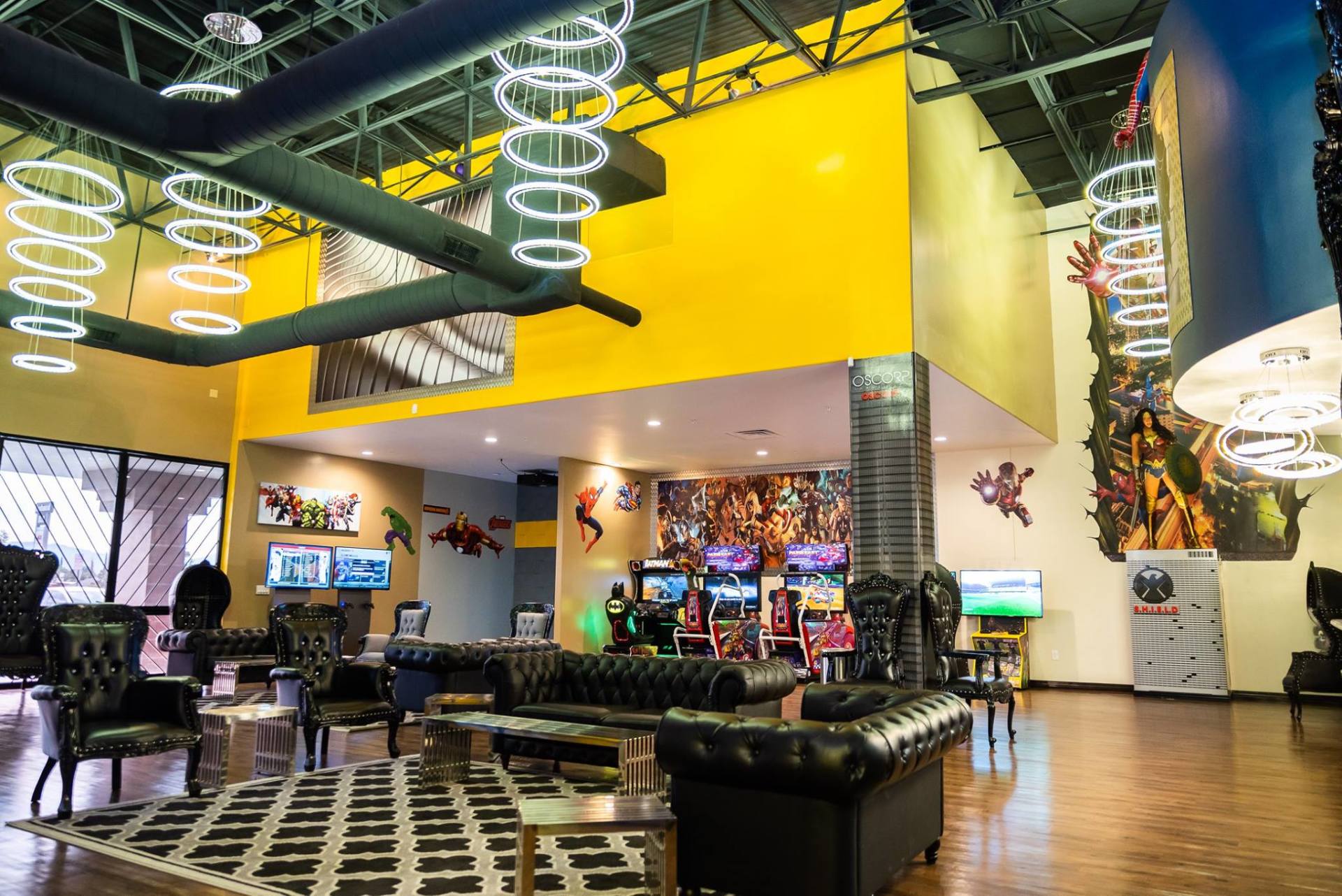 Colorful modern lobby with neon ring lights, black seating, and a bright yellow mezzanine area