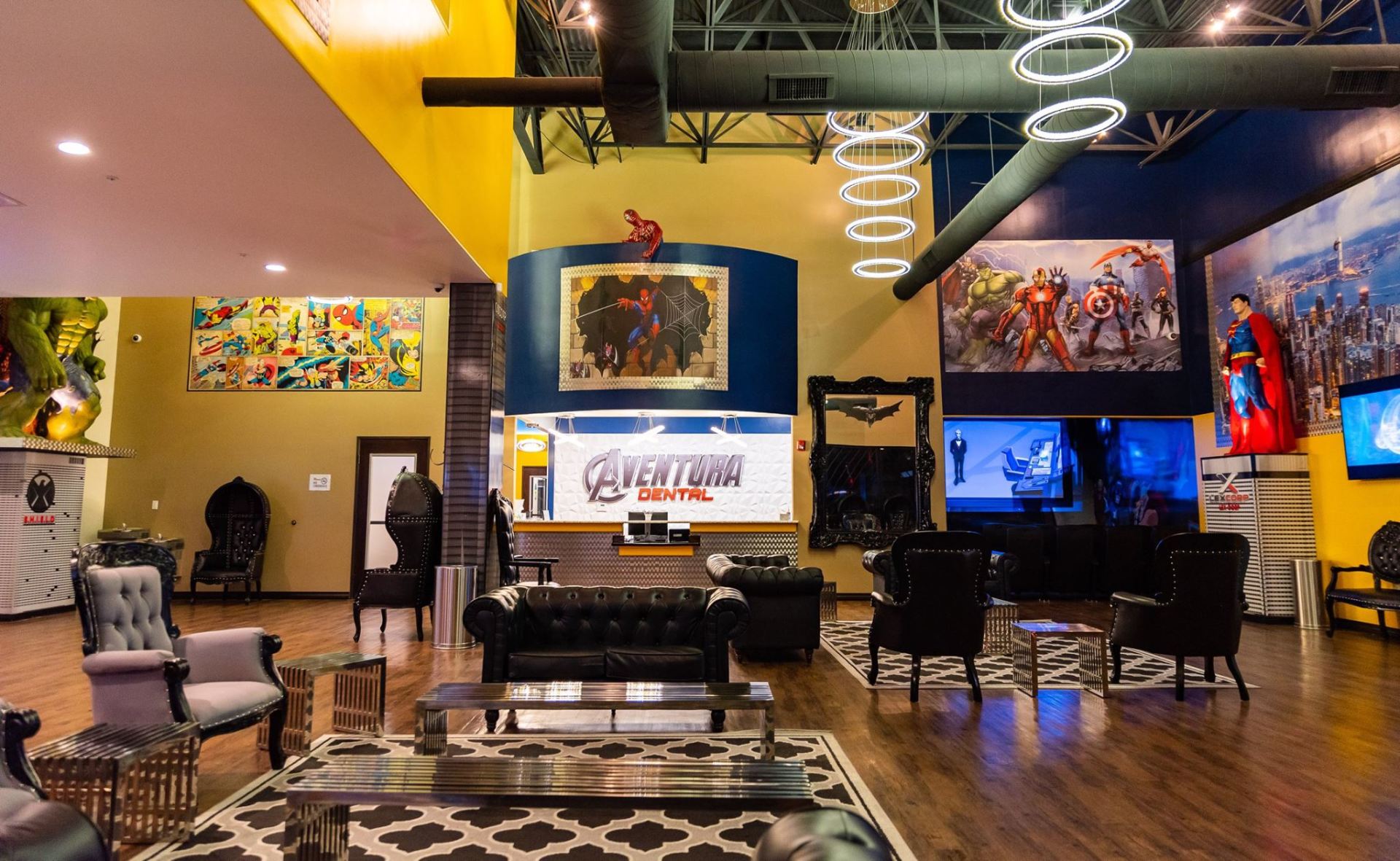 Modern entertainment lounge with colorful art, TVs, seating, and patterned rugs under warm lighting