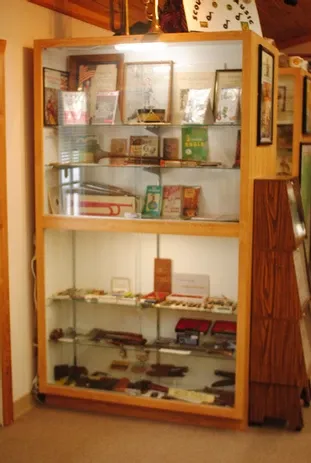 A tall glass display case of a number of scouting accessories