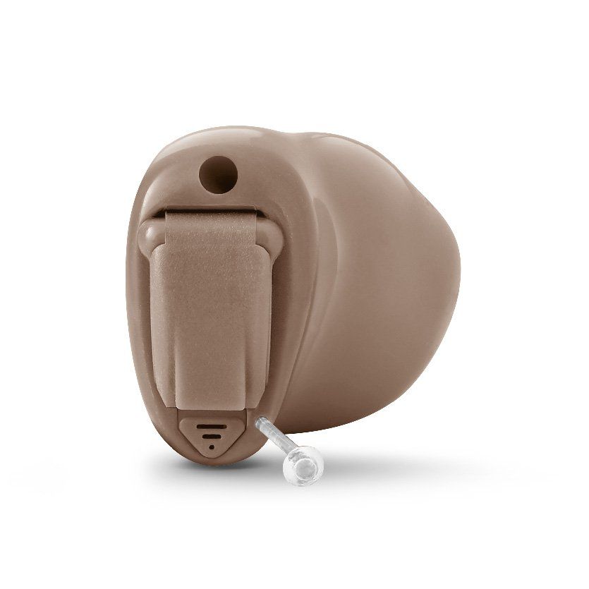 Audífono de color beige con tubo auditivo transparente, mostrado sobre un fondo blanco.