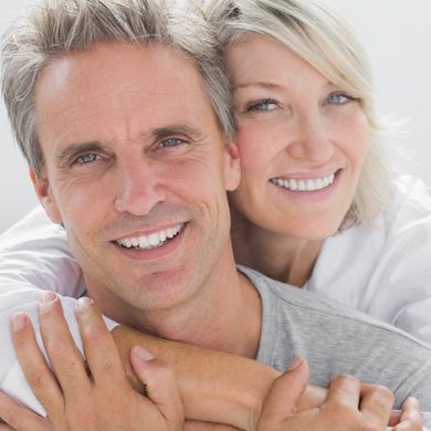 A man and woman are hugging and smiling for the camera