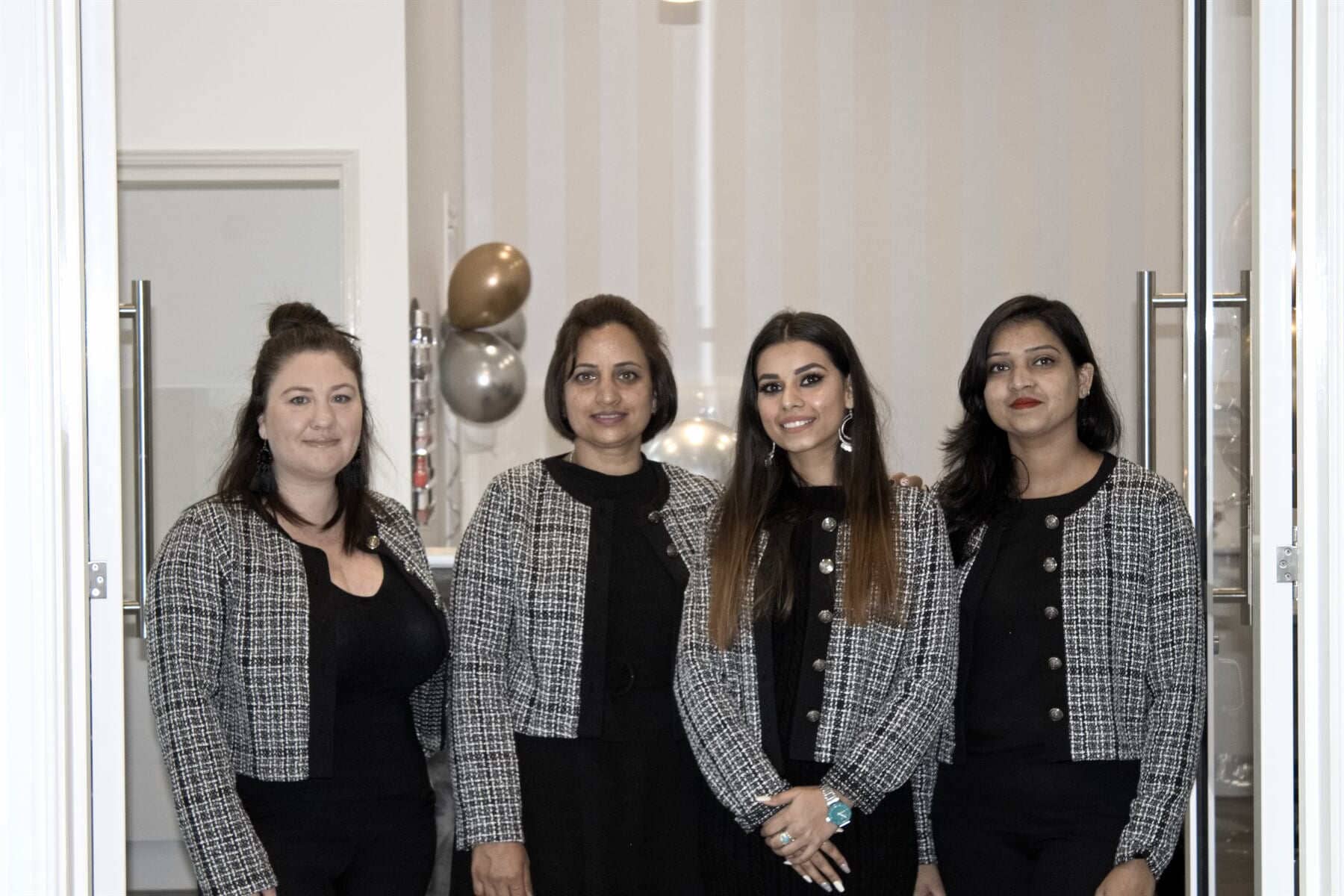 A group of women are posing for a picture in front of a door.
