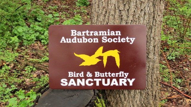 A sign for the bartramian audubon society bird and butterfly sanctuary