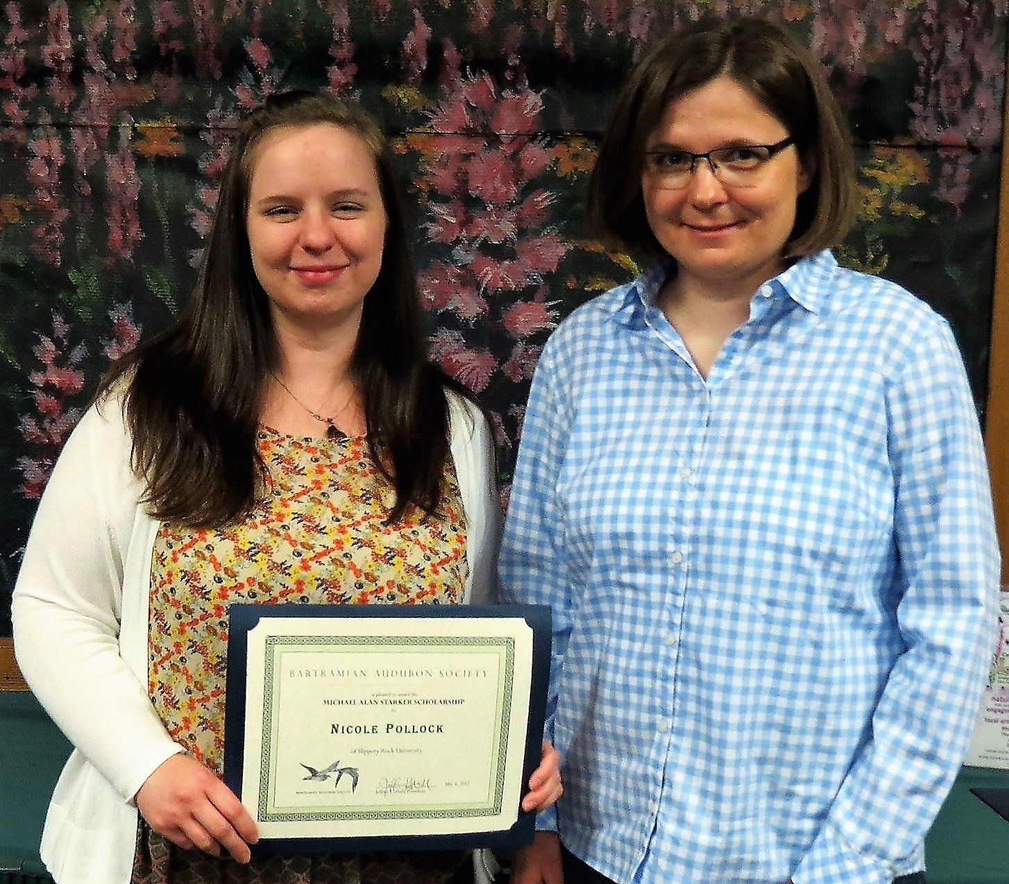 Two women standing next to each other holding a certificate