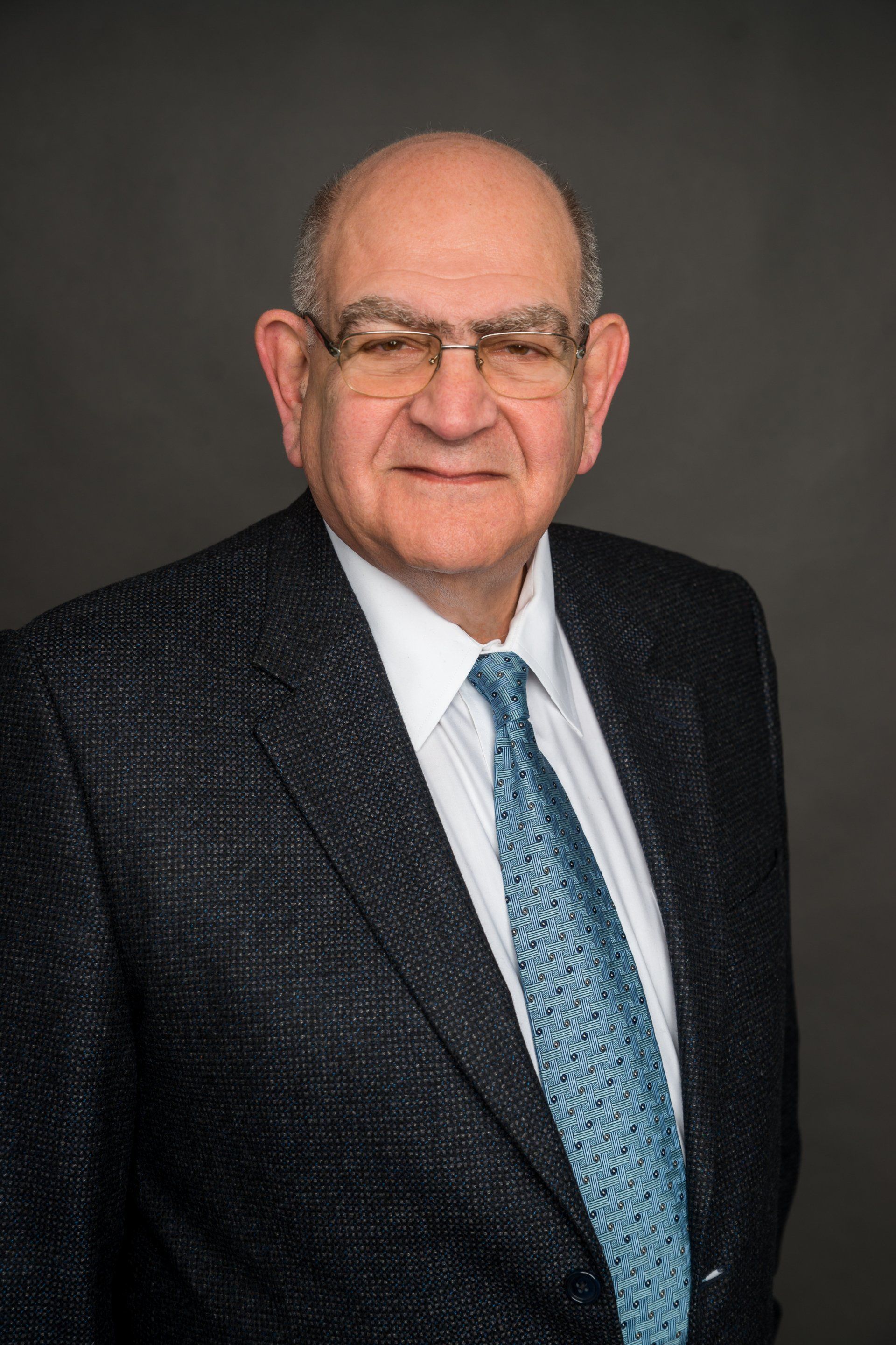 A man in a suit and tie is smiling for the camera.