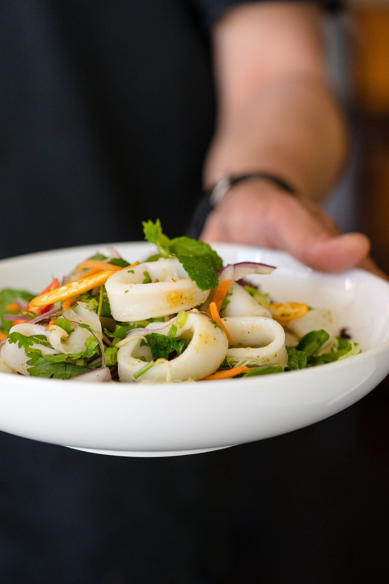 Our server is offering a calamari salad with seafood dressing.