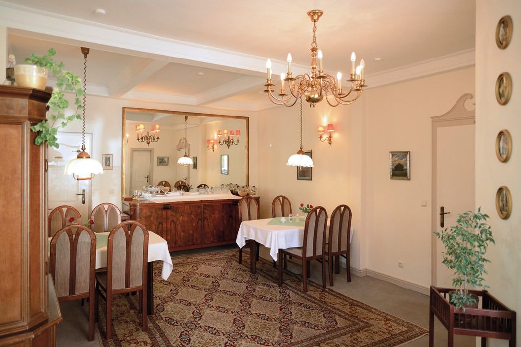 Ein Esszimmer mit Tischen und Stühlen und einem Kronleuchter