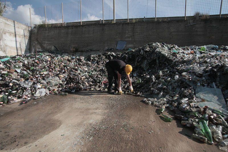 recupero di bottiglie di plastica in una discarica