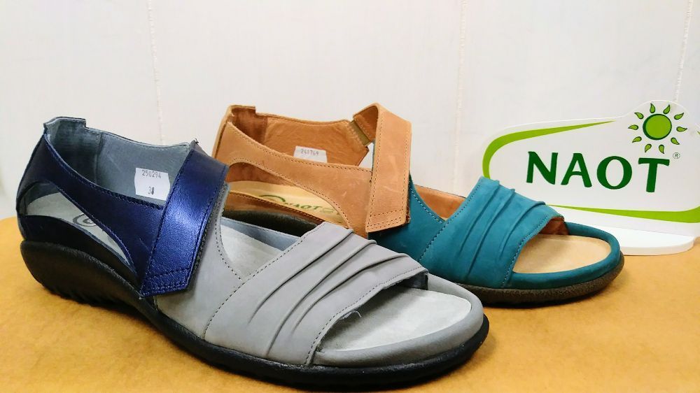 Two pairs of naot sandals are sitting on a table