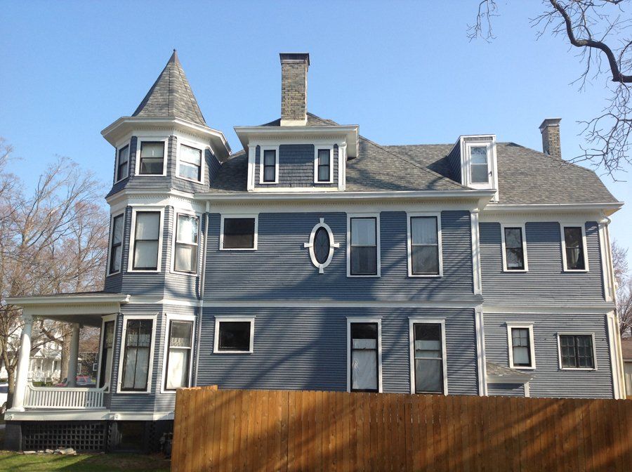 A large house with a wooden fence in front of it