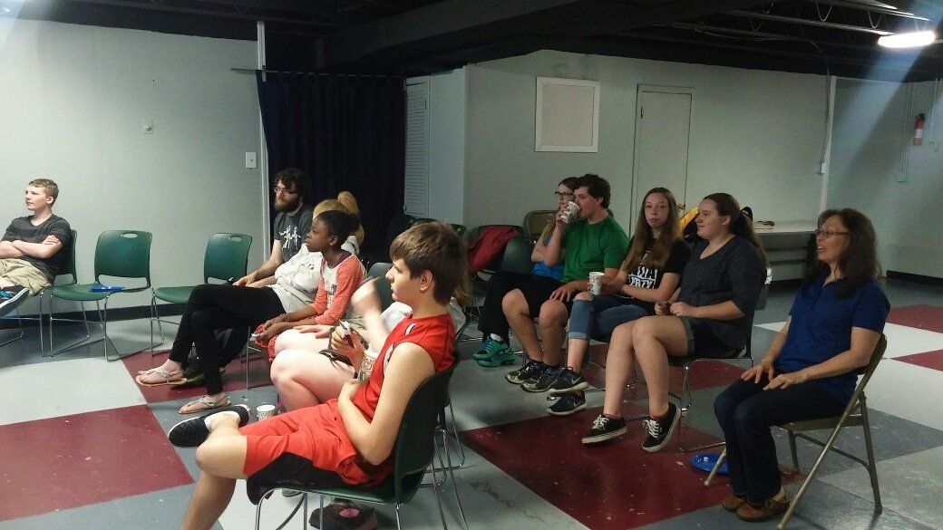 A group of people are sitting in chairs in a room.