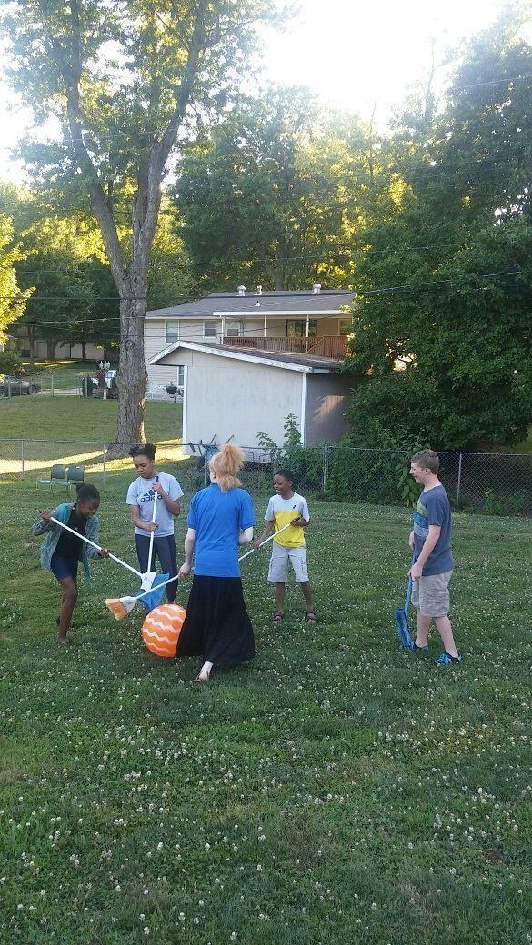 A group of children are playing in a grassy field.