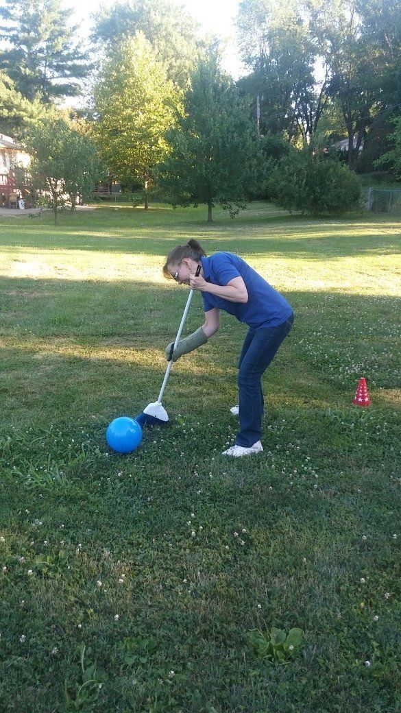  playing golf in a park with a blue ball.
