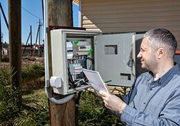 Technician Taking Reading Of Electric Meter - Electrical Contractor in Dewitt, MI Technician Taking Reading Of Electric Meter - Electrical Contractor in Dewitt, MI
