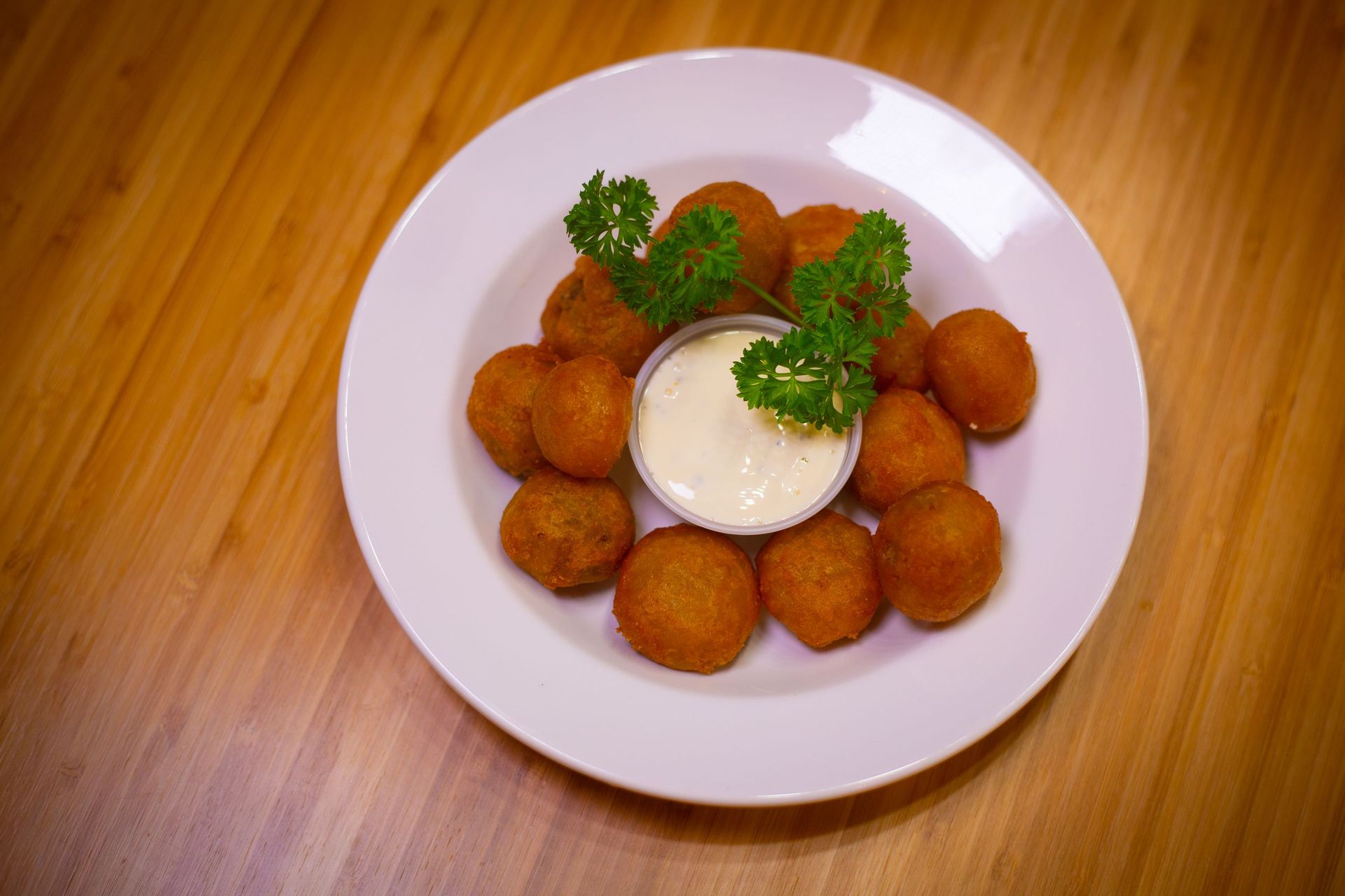 A plate of food with a dipping sauce on a wooden table.