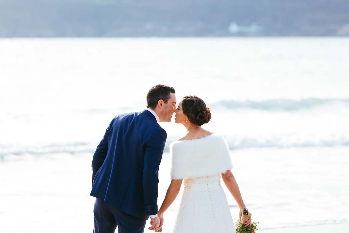 wedding couple kissing on beach at rosscarbery