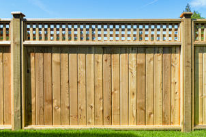 Worker Using Hand Drill on Wooden Fence — Wooden Fence in Caledonia, WI Worker Using Hand Drill on Wooden Fence — Wooden Fence in Caledonia, WI