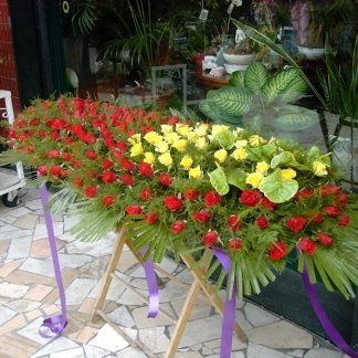 allestimento rose rosse e gialle per cofano funebre