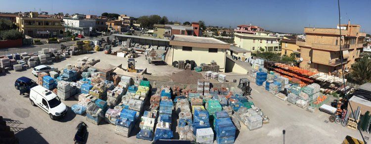 vista dall’alto di un furgone bianco, una macchina e dei bancali di materiale edile