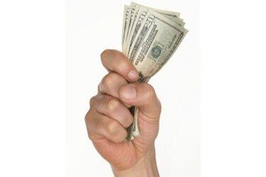 What We Buy — A hand with dollar money in Quarryville, PA What We Buy — A hand with dollar money in Quarryville, PA