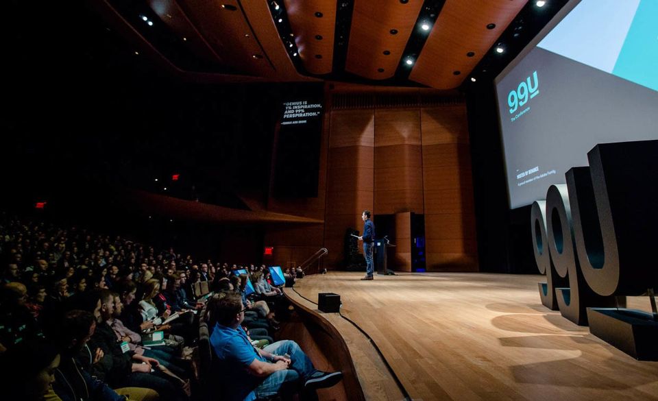 a picture of people listening to a speaker at the 99u conference