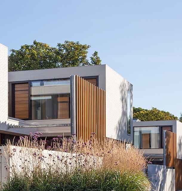 Contemporary glass facade of a home in Clontarf featuring white brick accents