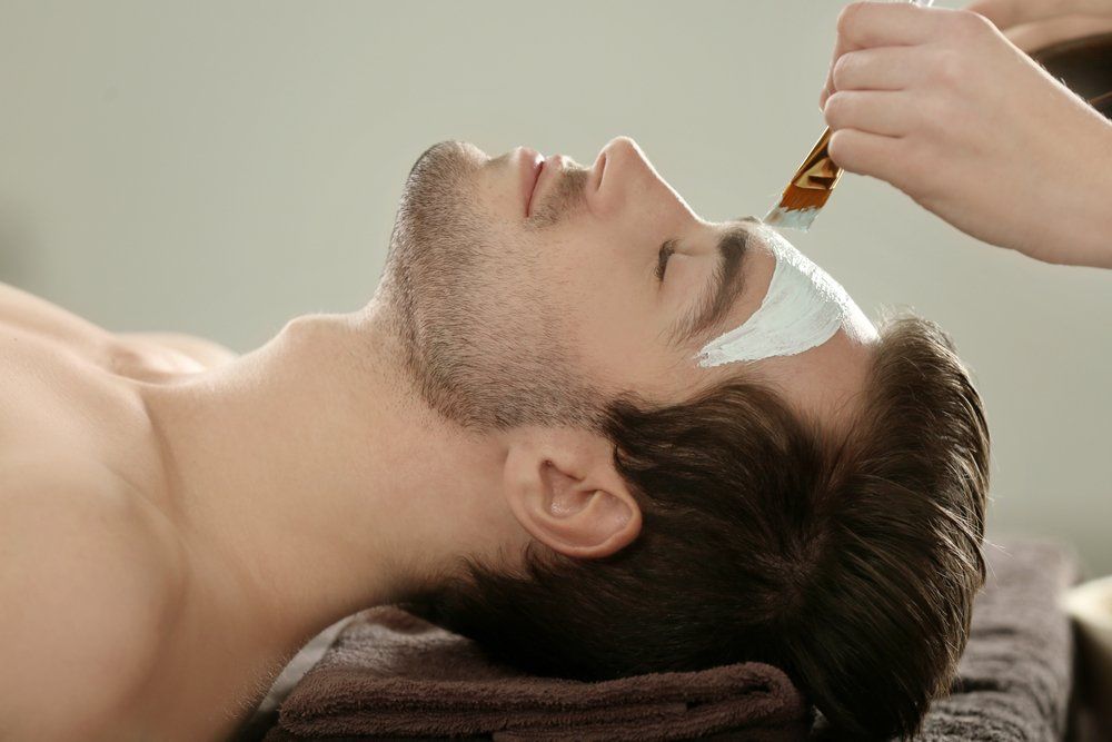 Ein Mann bekommt in einem Spa eine Gesichtsbehandlung.