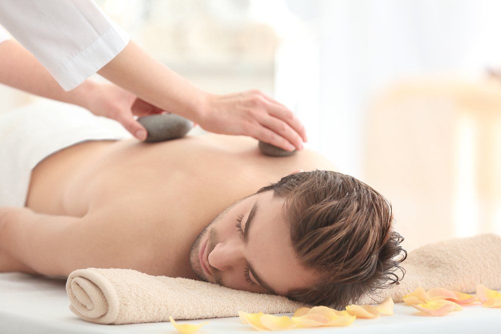 Ein Mann bekommt in einem Spa eine Hot-Stone-Massage.