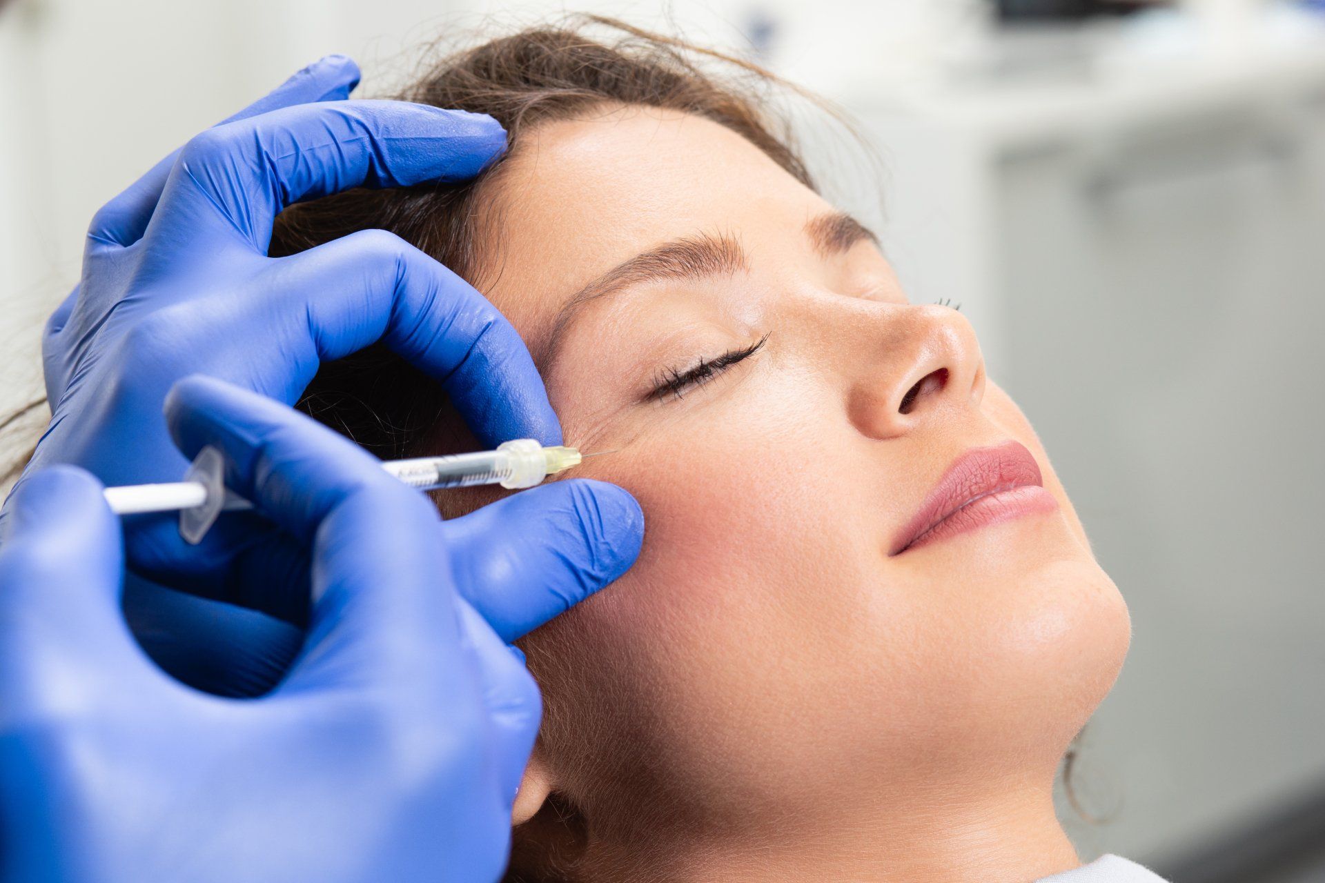 Eine Frau bekommt eine Botox-Injektion ins Gesicht.