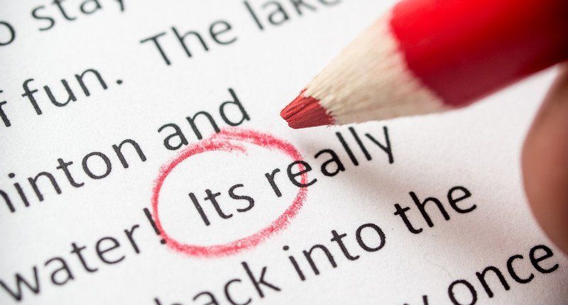 A person is using a red pencil to highlight the word water.