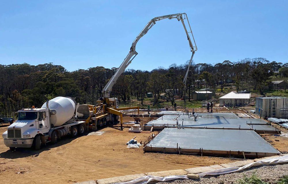 yellow concrete pumping truck at a construction site
