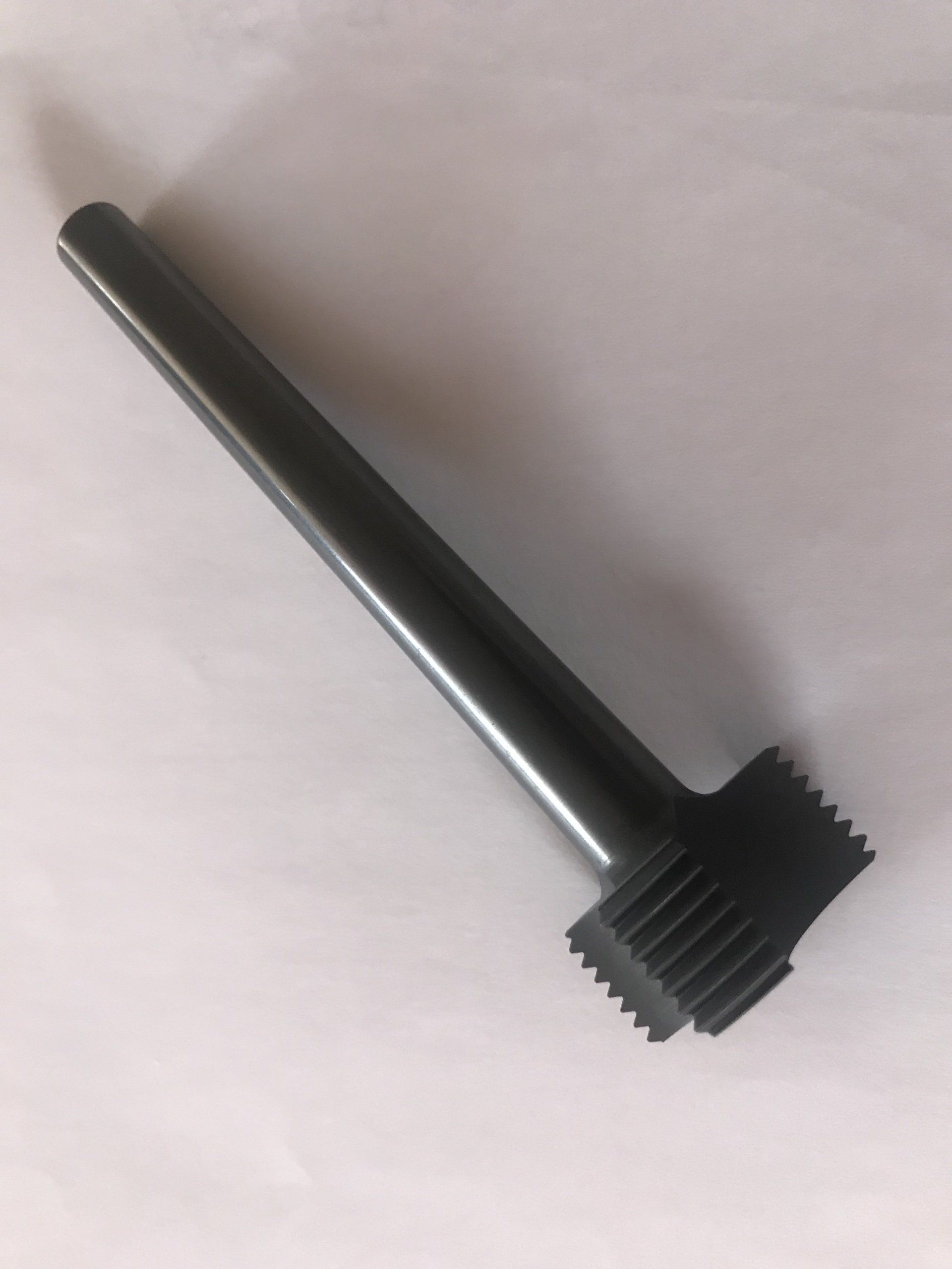 Ein schwarzer Plastikhammer liegt auf einer weißen Oberfläche.
