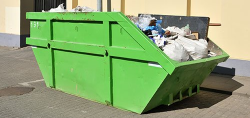 dumpster full of trash bags