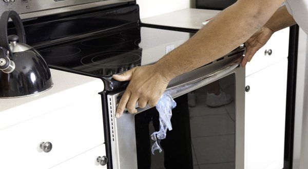 Serviceman Fixing an Oven — Voorhees, NJ — Appliance Werks