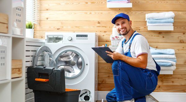 Man Plumber Repairs Washing Machine in Laundry — Voorhees, NJ — Appliance Werks Man Plumber Repairs Washing Machine in Laundry — Voorhees, NJ — Appliance Werks
