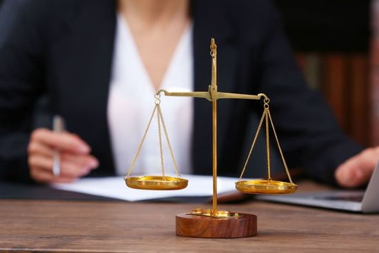 Primo piano della bilancia della giustizia davanti a una donna