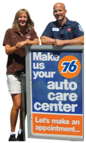 Two people at a 76 auto care sign. Woman in brown shirt, man in mechanic's uniform.