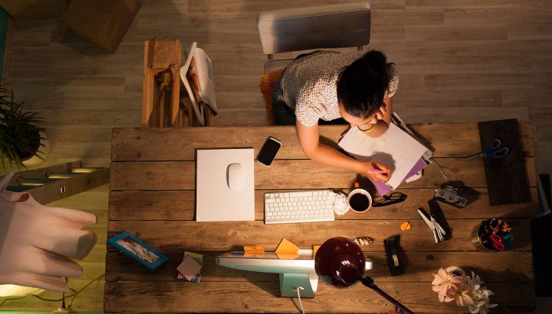 A woman is sitting at a desk in front of a computer.