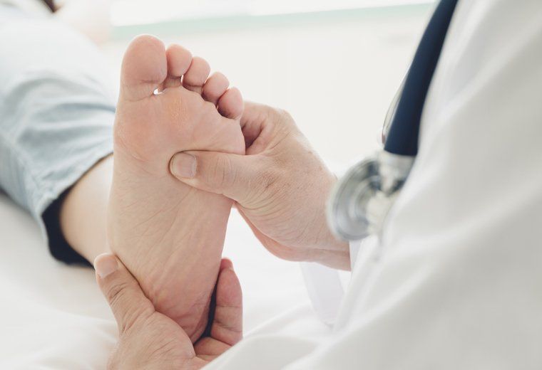 Doctor Checking Patient's Foot — Pensacola, FL — Pensacola Podiatry P.A. Doctor Checking Patient's Foot — Pensacola, FL — Pensacola Podiatry P.A.