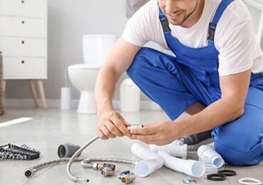 Plumber Working on Pipe and Hose — Plumbers in Forster, NSW Plumber Working on Pipe and Hose — Plumbers in Forster, NSW